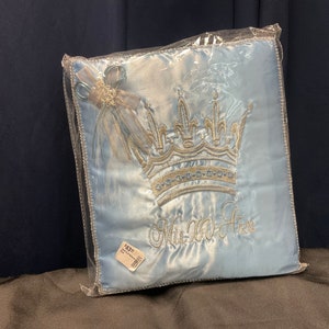 May include: A light blue satin pillow with a silver embroidered crown and the text "His Royal Highness".