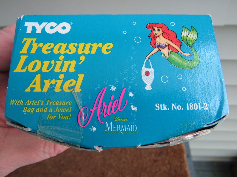 May include: A blue box with a picture of Ariel from Disney's The Little Mermaid. The box says "TYCO Treasure Lovin' Ariel" and "Stk. No. 1801-2".