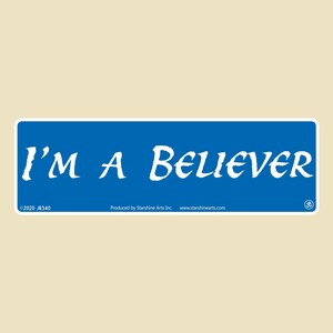 May include: Blue rectangular sticker with white text that reads "I'M A BELIEVER" in a cursive font. The sticker also includes copyright information and the company name "StarShine Arts Inc."