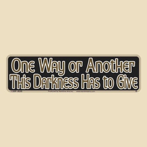 May include: Black and white rectangular sign with the text "One Way or Another This Darkness Has to Give" in brown lettering. The sign has a white border and a copyright symbol with the year 2019 and the letters JR205.
