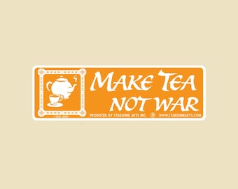 May include: An orange sticker with the text "MAKE TEA NOT WAR" in white script. The sticker features a white teapot and teacup graphic within a decorative border. The sticker also includes the text "PRODUCED BY STARSHINE ARTS INC" and a website address.