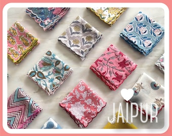 Pode incluir: Uma coleção de 11 lenços de algodão coloridos com padrões florais e geométricos. Os lenços têm bordas festonadas e estão dispostos sobre uma superfície de mármore branco. A palavra "JAIPUR" está escrita em letras brancas sobre um fundo em forma de coração.