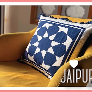 May include: A blue and white patterned cushion with a geometric design sits on a yellow armchair. The cushion has a white frilled trim and the text "JAIPUR" is visible in the lower right corner of the image.