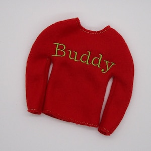 May include: Red long-sleeved elf shirt with the word "Buddy" embroidered in green thread.