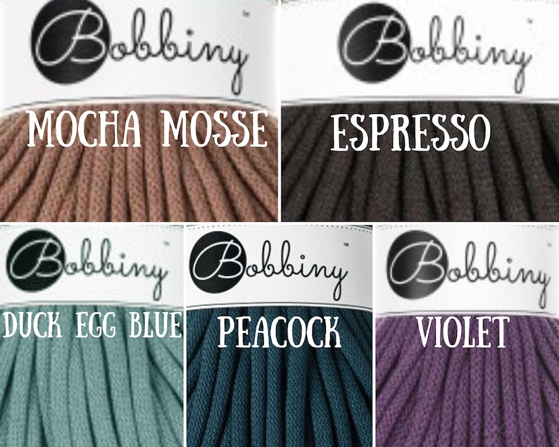 Puede incluir: Seis carretes de cuerda de algod&oacute;n en diferentes colores. Los colores son moca, espresso, azul huevo de pato, pavo real y violeta. Cada carrete tiene una etiqueta blanca con la palabra "Bobbiny" en negro y el nombre del color en negro.