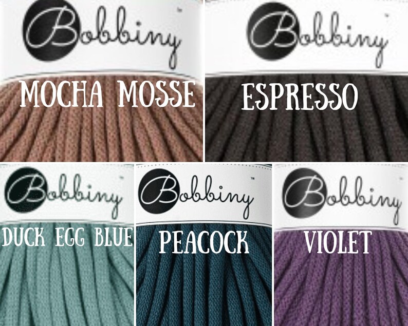 Puede incluir: Seis carretes de cuerda de algod&oacute;n en varios colores, incluyendo moca, espresso, azul huevo de pato, pavo real y violeta. Cada carrete tiene una etiqueta blanca con la palabra "Bobbiny" en letras negras y el nombre del color debajo.