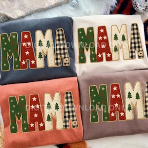 Könnte beinhalten: Vier Sweatshirts mit dem Wort "MAMA" in einem festlichen Design. Die Buchstaben sind mit grünen, roten und weißen Akzenten verziert, darunter Sterne, Weihnachtsbäume und Karomuster. Jedes Sweatshirt hat eine andere Farbe: Marineblau, Weiß, Koralle und Mauve.
