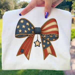 Op de afbeelding: Een patriottisch strikdesign met de kleuren van de Amerikaanse vlag. De strik heeft een blauw midden met gouden sterren, rood-wit gestreepte secties en een bungelende ster. Het ontwerp staat op een witte achtergrond.