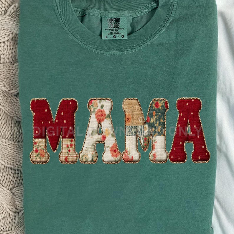 May include: A teal green sweatshirt with the word "MAMA" appliqued across the front. The letters are a mix of floral and patterned fabrics, with red polka dot fabric on the M's and A. The shirt has a crew neck and long sleeves.