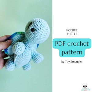 Puede incluir: Un patrón de crochet para una pequeña tortuga azul con un caparazón arcoíris. El patrón se llama "Pocket Turtle" y es de Toy Smuggler.