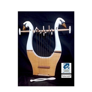 May include: A white wooden lyre with swan heads, 7 strings, and a wooden tuning peg. The lyre is on a black background. The text "archeologia sperimentale" and "ARCHO LIRA" is visible in the lower right corner of the image.