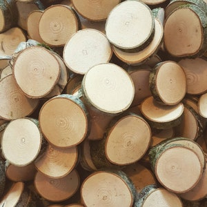 May include: A pile of natural wood slices, each with a unique grain pattern and a smooth, light brown surface. The wood slices are perfect for crafting, decorating, or adding a rustic touch to your home.