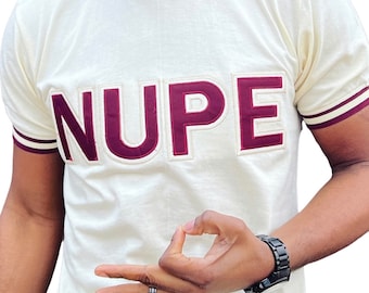 Puede incluir: Una camiseta blanca con un "NUPE" bordado en granate en la parte delantera. La camiseta tiene rayas granate y blancas en el cuello y las mangas.
