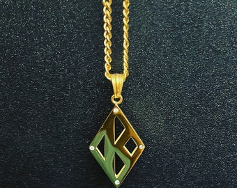 Pode incluir: Um colar de corrente de ouro com um pingente em forma de diamante. O pingente tem um design geométrico com recortes e pequenas pedras transparentes.