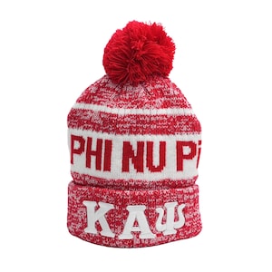 May include: Red and white knit beanie with a pom pom on top. The beanie has the letters "PHI NU PI" and "KAΨ" knitted into the fabric.