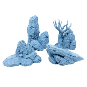 Op de afbeelding: Een set van vijf blauwe 3D-geprinte rotsformaties, waaronder een hoge, dunne rots, een kortere, bredere rots, een kleine rots met een puntige top, een grote, platte rots en een boomstronk met takken.