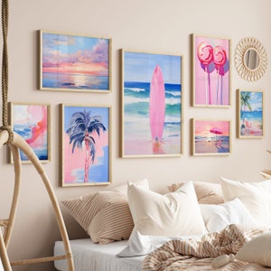 May include: A collection of framed art prints featuring beach scenes, palm trees, and a pink surfboard. The prints are arranged in a grid pattern on a pale pink wall above a bed with striped bedding.