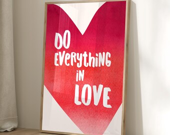 May include: A framed print featuring a watercolour heart design in shades of pink and red. The text "Do everything in love" is written in white on the heart.