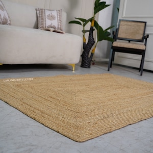 Puede incluir: Una alfombra de fibra natural hecha de yute, con una textura tejida y un color marr&oacute;n claro. La alfombra es rectangular y tiene un borde ligeramente deshilachado.