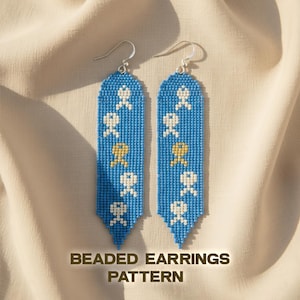 May include: A pair of beaded earrings with a blue background and white and gold-colored figures. The earrings have a long, rectangular shape with a pointed bottom. The text "BEADED EARRINGS PATTERN" is at the bottom of the image.