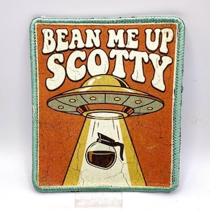 May include: Rectangular patch with the phrase "BEAN ME UP SCOTTY" above an illustration of a UFO beaming down a coffee pot. The patch has a distressed orange background, a green border, and a retro design.
