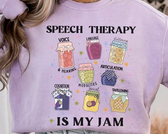 May include: A light purple sweatshirt with the text "SPEECH THERAPY IS MY JAM." The design features jars with labels like "VOICE," "LANGUAGE," and "ARTICULATION." The sweatshirt is a comfortable, casual style.