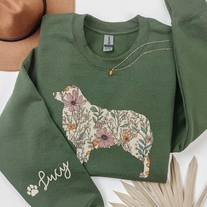May include: A green sweatshirt with a floral dog silhouette and the name "Lucy" on the sleeve.