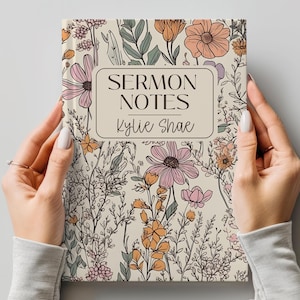 Może przedstawiać: Notatnik w kwiatowy wzór z napisem "SERMON NOTES Kylie Shae" w prostokątnej ramce. Notatnik ma kremowe tło z ilustracjami różowych, pomarańczowych i zielonych kwiatów. Notatnik jest trzymany przez dwie ręce.