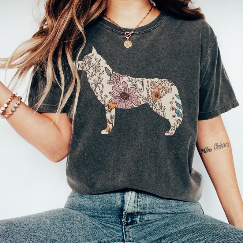 May include: A dark gray t-shirt with a floral print of a husky silhouette. The flowers are in shades of pink, yellow, and blue.