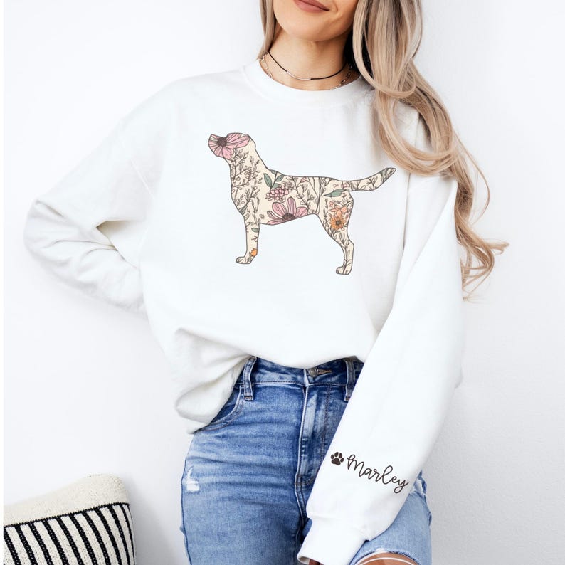 May include: White sweatshirt with a floral Labrador Retriever silhouette design. The sweatshirt has a black paw print and the name "Marley" on the left sleeve.