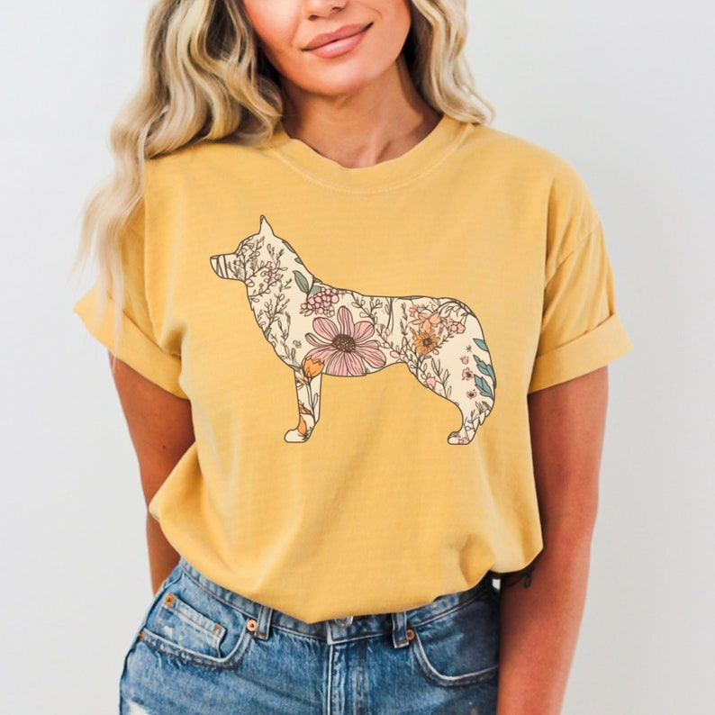 May include: A yellow t-shirt with a floral design of a husky dog silhouette. The flowers are in shades of pink, yellow, and green.