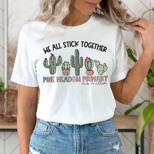 May include: White t-shirt with a graphic of cacti and the text "We all stick together Pine Meadow Primary Ms. Miller"