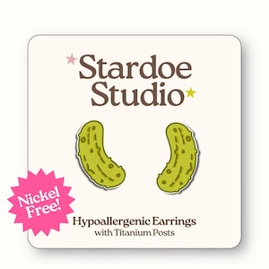 Peut inclure: Une paire de boucles d'oreilles en forme de cornichon vert sur une carte de présentation blanche. La carte porte le texte Stardoe Studio, une étoile rose, une étoile jaune et un éclat rose avec le texte Nickel Free. Hypoallergenic Earrings with Titanium Posts est inscrit en dessous.