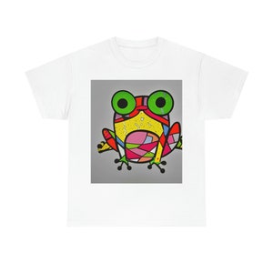 May include: A white t-shirt with a colorful cartoon frog design. The frog is yellow, red, green, pink, and blue. The frog has large green eyes.