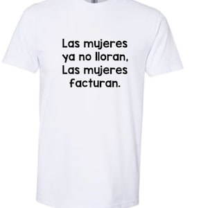 May include: White t-shirt with the Spanish text "Las mujeres ya no lloran. Las mujeres facturan." printed in black. The shirt has short sleeves and a crew neck.