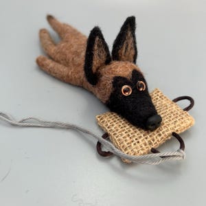 Adorno/llavero de fieltro con forma de perro Malinois mordiendo.