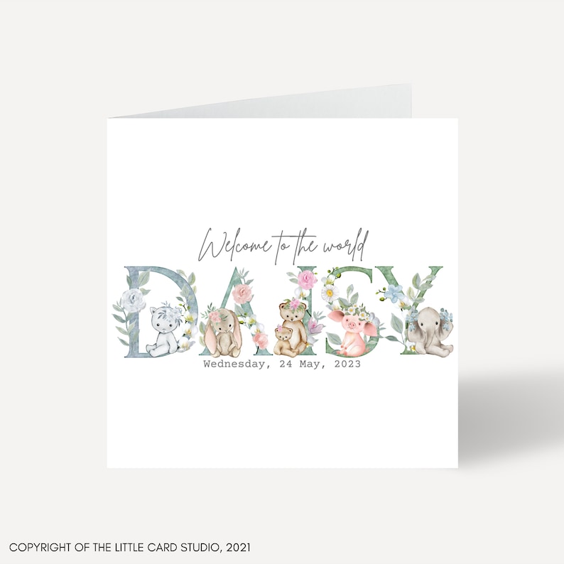 May include: A white card with the text "Welcome to the world DAISY" in a blue and green floral font. The letters are decorated with small animal illustrations. The date "Wednesday, 24 May, 2023" is printed below the name.