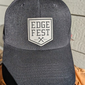 May include: Black baseball cap with a silver patch that says "EDGE FEST ESTD 2014" with a crossed axe design.
