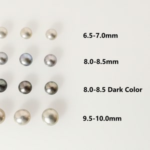 Könnte beinhalten: Eine Auswahl an Perlen in verschiedenen Größen und Farben, darunter Weiß, Grau und Schwarz. Die Perlen sind in Reihen angeordnet, wobei die Größe von links nach rechts zunimmt. Die Größen sind mit 6,5-7,0 mm, 8,0-8,5 mm, 8,0-8,5 Dunkel und 9,5-10,0 mm gekennzeichnet.