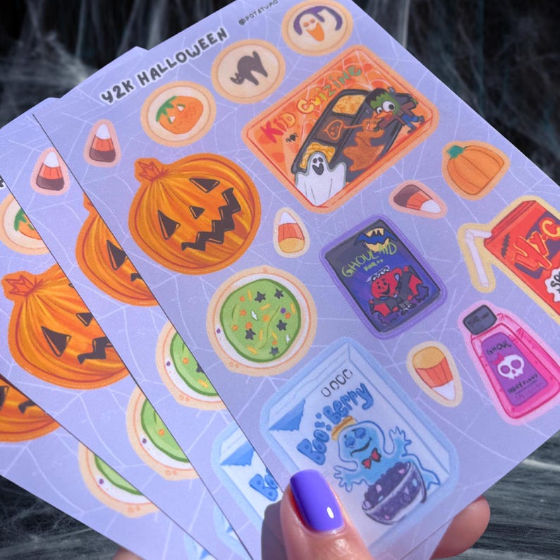 May include: Sheets of Halloween-themed stickers with various designs, including pumpkins, ghosts, and candy corn. The stickers feature the text "42K Halloween" and "Kid Cazing". The color palette includes orange, purple, green, and white.