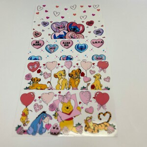 May include: A set of four Valentine's Day themed sticker sheets featuring Disney characters. The sheets feature Stitch, Simba, and Winnie the Pooh. The stickers are printed on clear sheets and have a variety of designs, including hearts, balloons, and candy.
