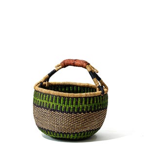Op de afbeelding: Een ronde geweven mand met een handvat. De mand heeft een patroon van groene en zwarte strepen tegen een bruine achtergrond. Het handvat is omwikkeld met bruin leer. Deze decoratieve mand is ideaal voor opslag of weergave.