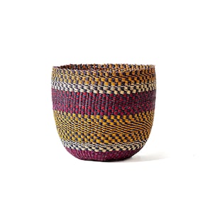 Peut inclure: Un panier tissé à la forme arrondie. Le panier présente un motif rayé dans des tons bordeaux, jaunes et noirs. Fabriqué à partir de fibres naturelles, il a une surface texturée. Adapté au rangement ou à la décoration, ce panier est polyvalent.