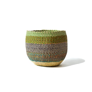Peut inclure: Un panier rond tissé avec un motif rayé coloré. Le panier présente des bandes vertes, orange, noires, bleues et beiges. Le panier mesure environ 20 cm de diamètre et 18 cm de hauteur.