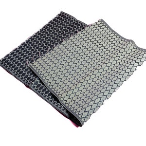 May include: Two woven mats with a diamond pattern. One mat is black with a white diamond pattern and the other is light green with a black diamond pattern.