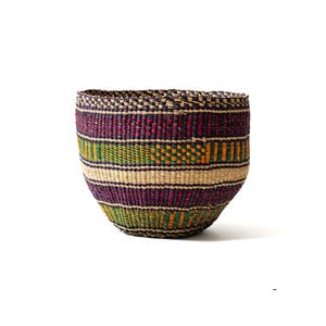 Peut inclure: Un panier tissé à la main de forme arrondie et à large ouverture. Le panier présente des bandes horizontales de couleurs, notamment violet, vert, orange et beige. Le bord a un motif texturé violet foncé.