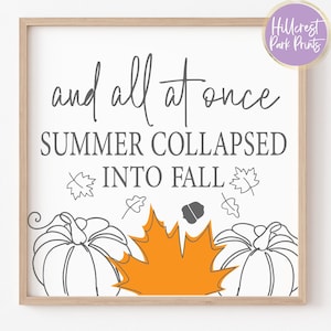 May include: A white framed print with the text "and all at once summer collapsed into fall" in gray text. The print features a stylized orange maple leaf and two black and white pumpkins.
