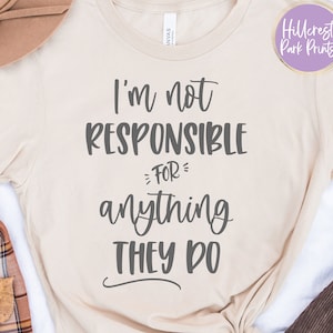 May include: A beige t-shirt with the text "I'm not responsible for anything they do" printed in gray.