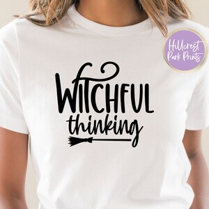 May include: White t-shirt with black text that reads "Witchful thinking" and a small black broom graphic.