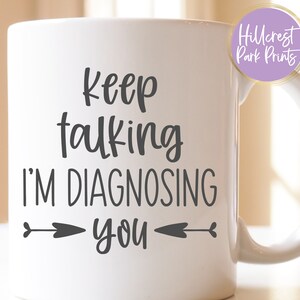 May include: White ceramic mug with black text that reads "Keep talking I'm diagnosing you" with two arrows pointing towards the text.